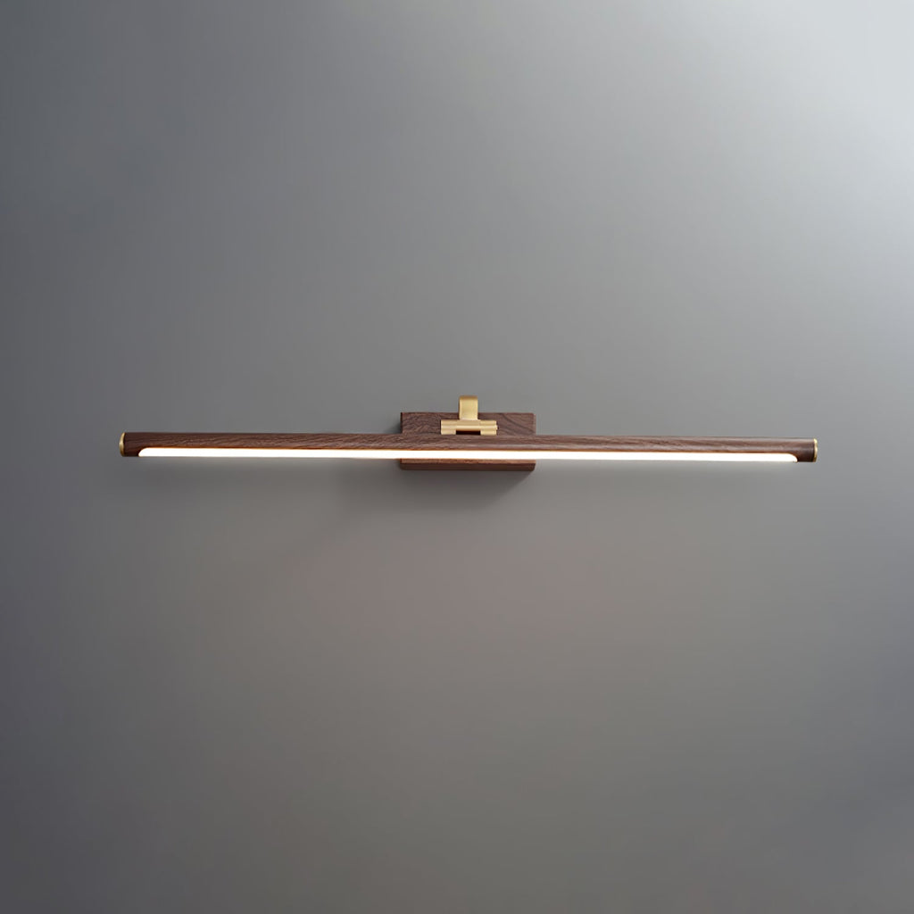 Straight-on view of this Clérachic wall light in walnut and brass, lit, on plain grey.