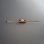 Straight-on view of this Clérachic wall light in walnut and brass, lit, on plain grey.