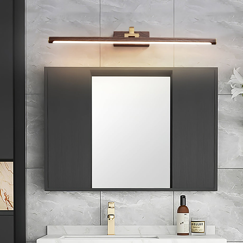 Mirrored cabinet doors sit below this Clérachic wall light in walnut and brass, over a dark wood vanity.