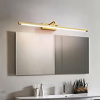 Small potted succulents sit on a white vanity beneath this Clérachic wall light in brass, above a mirrored cabinet.