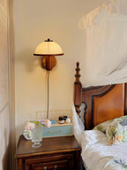 Oak mushroom wall lamp casting a gentle warm glow on the wall
