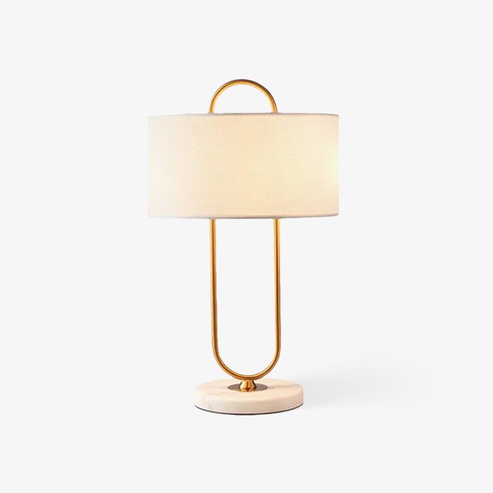 On a plain light grey background, this Clérachic table lamp's linen shade glows warm above its round marble base.