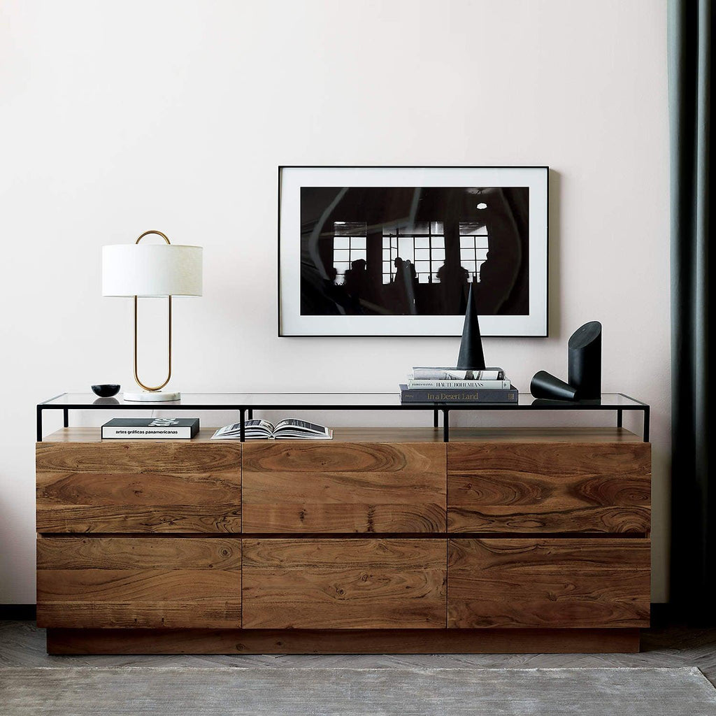 On a walnut console table beneath a framed print, this Clérachic table lamp adds ambient light near a stack of books.