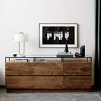 On a walnut console table beneath a framed print, this Clérachic table lamp adds ambient light near a stack of books.