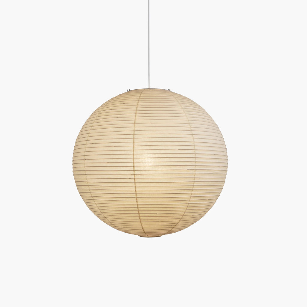 Washi paper pendant glowing above a dining setting