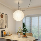 White paper globe pendant light over a styled table