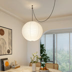 White paper globe pendant light over a styled table