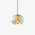 Close view of this Clérachic pendant's amber glass shade and gold frame, lit softly on a white background.