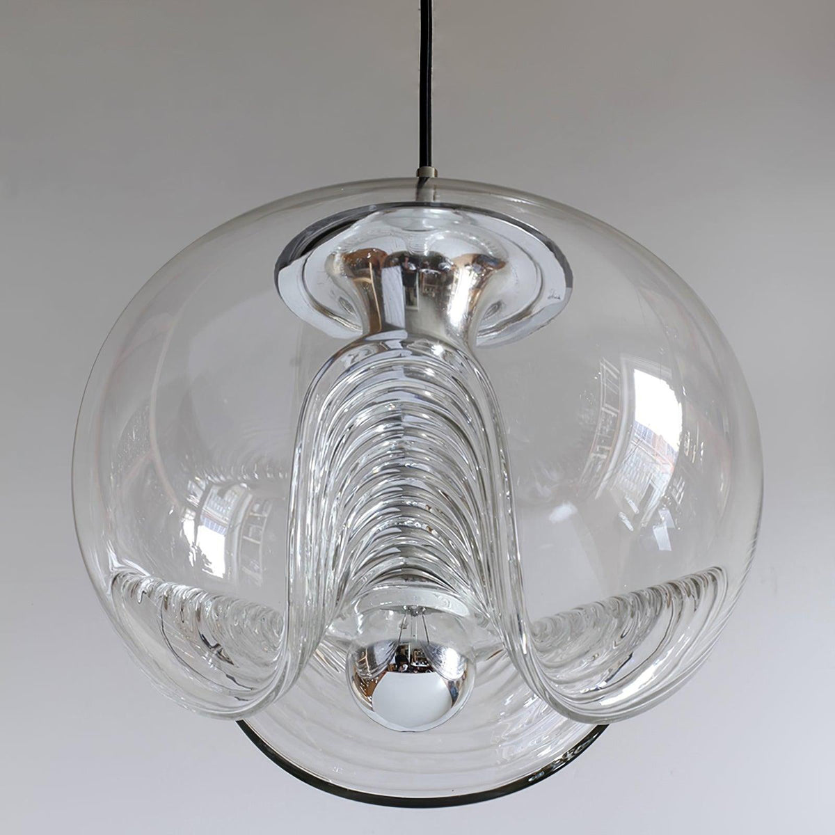 Close view of this Clérachic pendant's clear glass shade, its ribbed scalloped underside and chrome fitter shown in sharp detail against white.