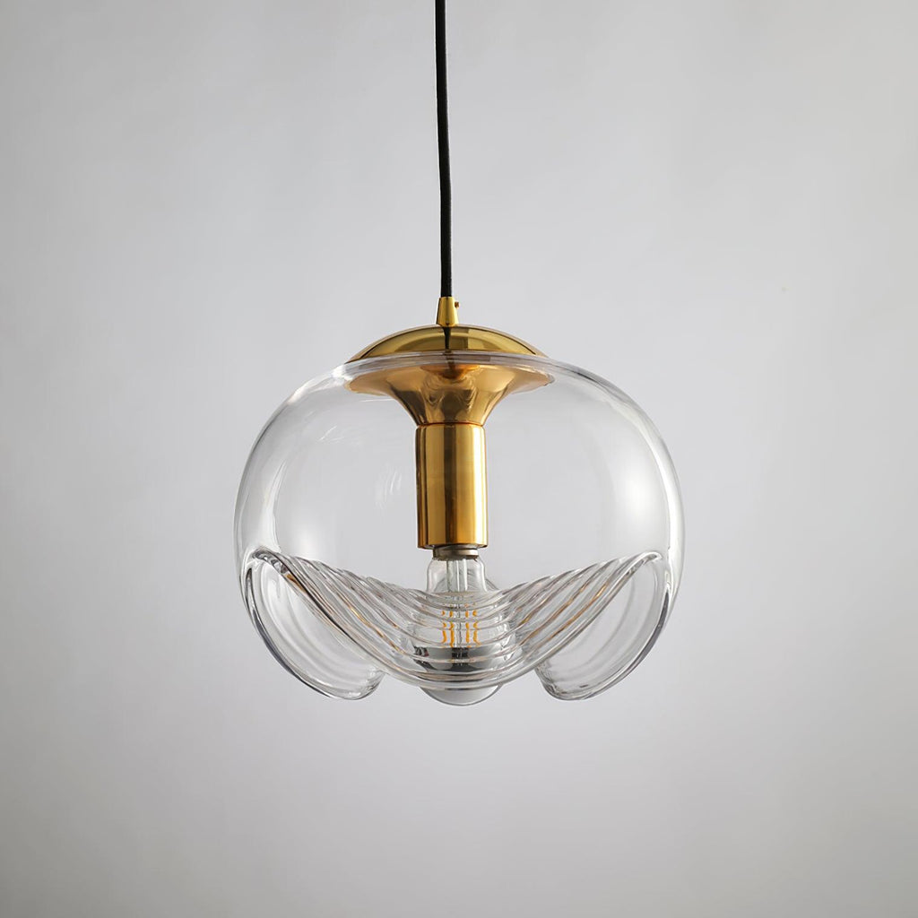 Close view of this Clérachic pendant's clear glass shade and gold frame, its scalloped ribbed underside shown on a white background.
