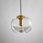 Close view of this Clérachic pendant's clear glass shade and gold frame, its scalloped ribbed underside shown on a white background.