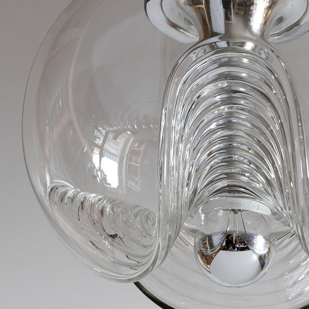 Close view of this Clérachic pendant's clear glass shade, its ribbed scalloped folds catching daylight around a chrome socket.
