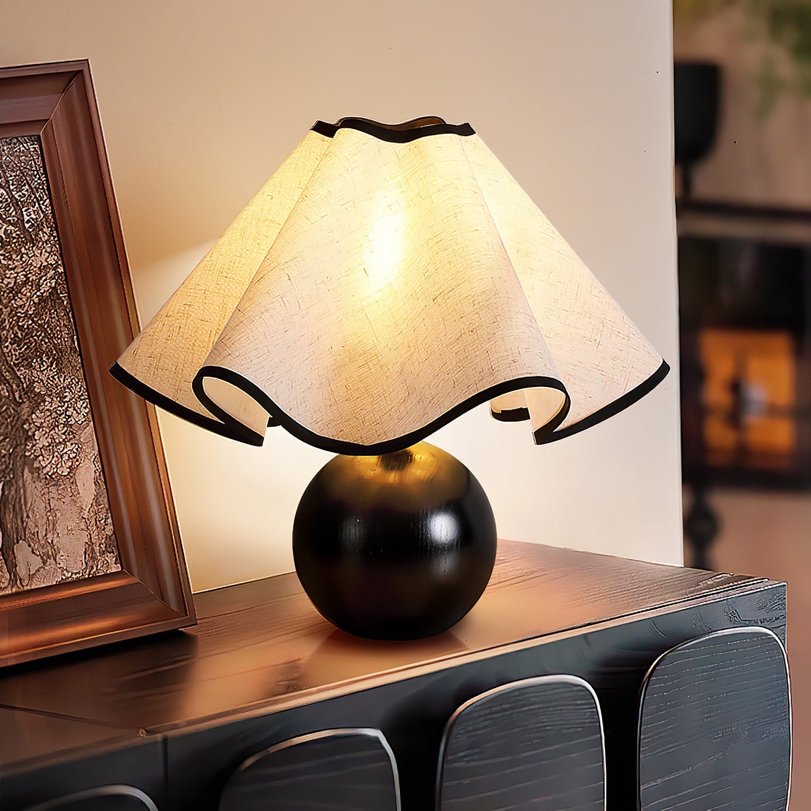Wavecrest table lamp lit on a table in a warm interior