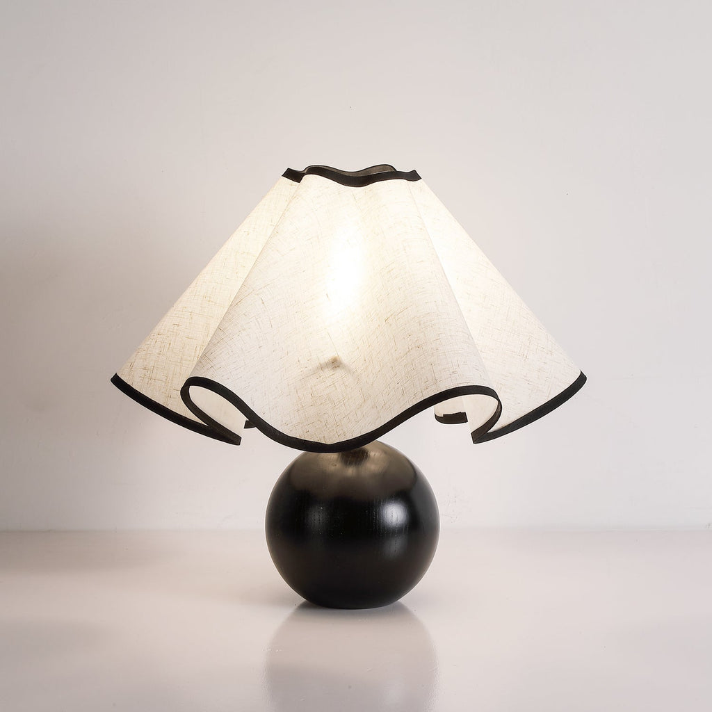 Wavecrest table lamp lit warmly beside a sofa in a cozy living room