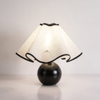 Wavecrest table lamp lit warmly beside a sofa in a cozy living room