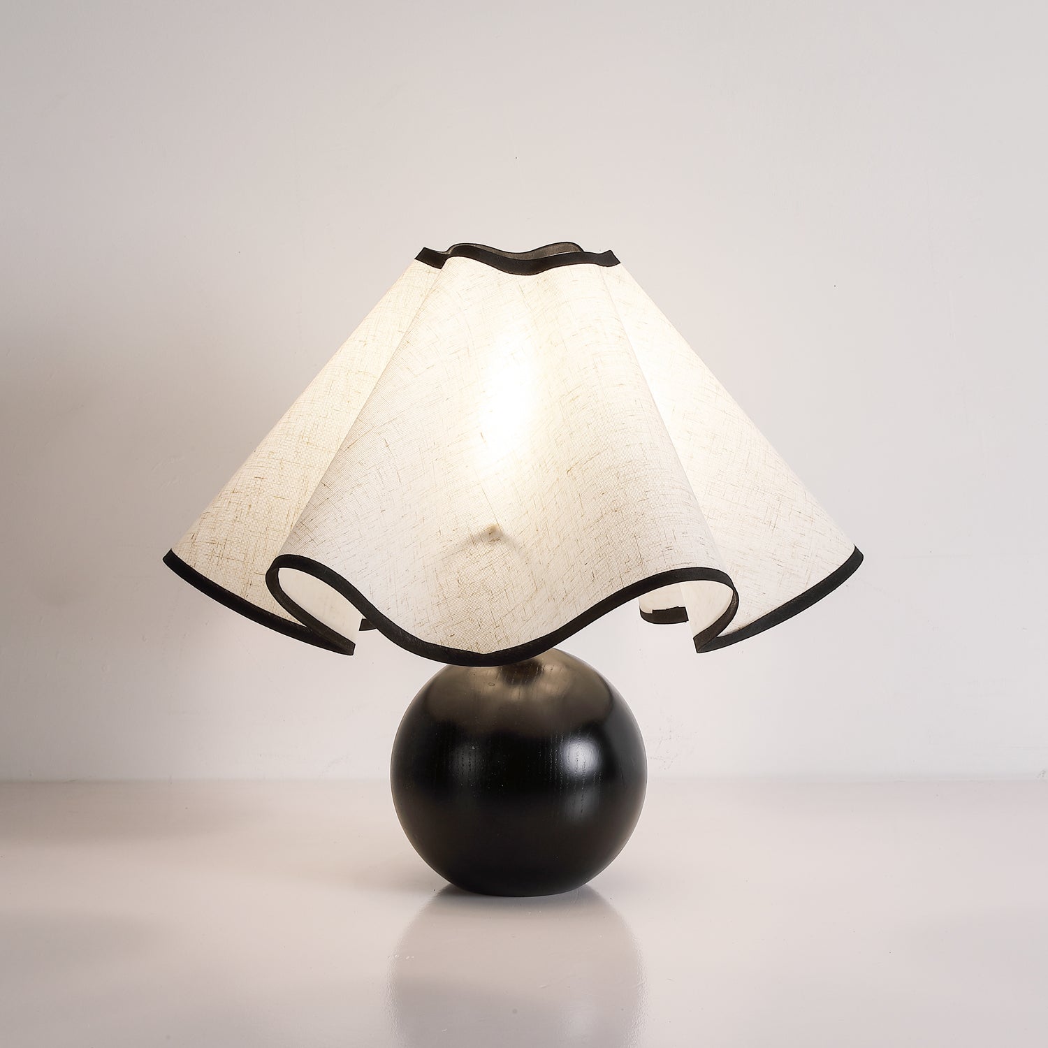 Wavecrest table lamp lit warmly beside a sofa in a cozy living room