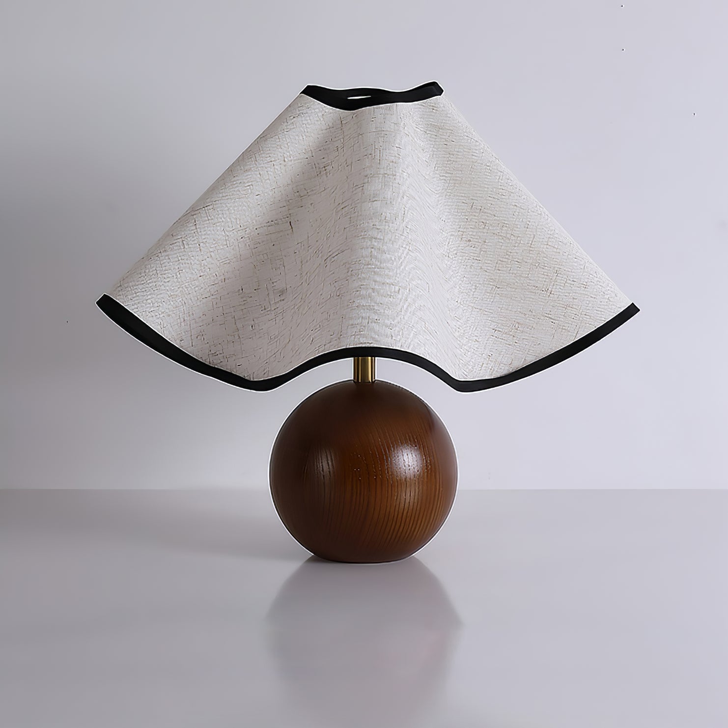 Wavecrest table lamp lit against a calm neutral wall