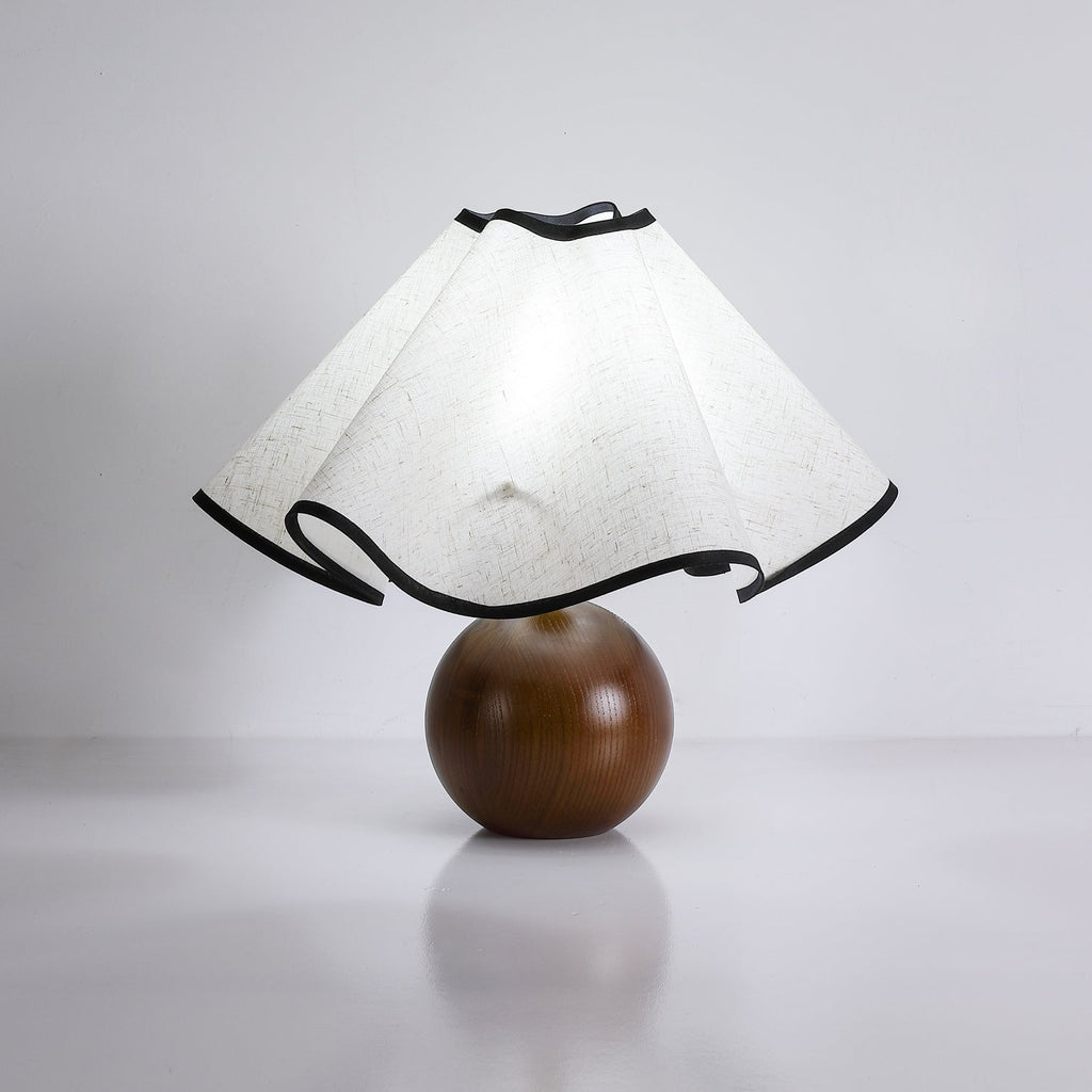 Wavecrest table lamp glowing beside a chair in a quiet corner