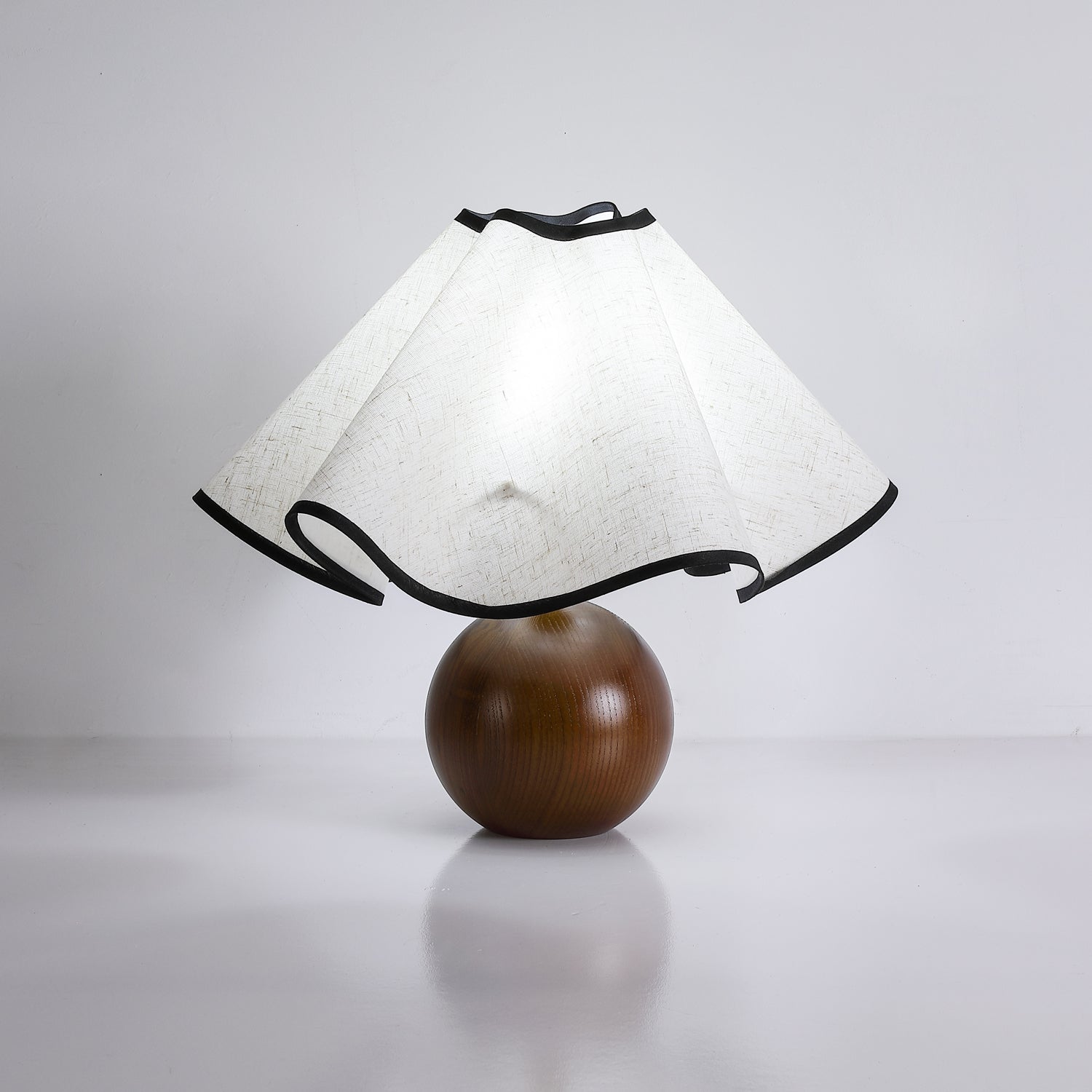 Wavecrest table lamp glowing beside a chair in a quiet corner