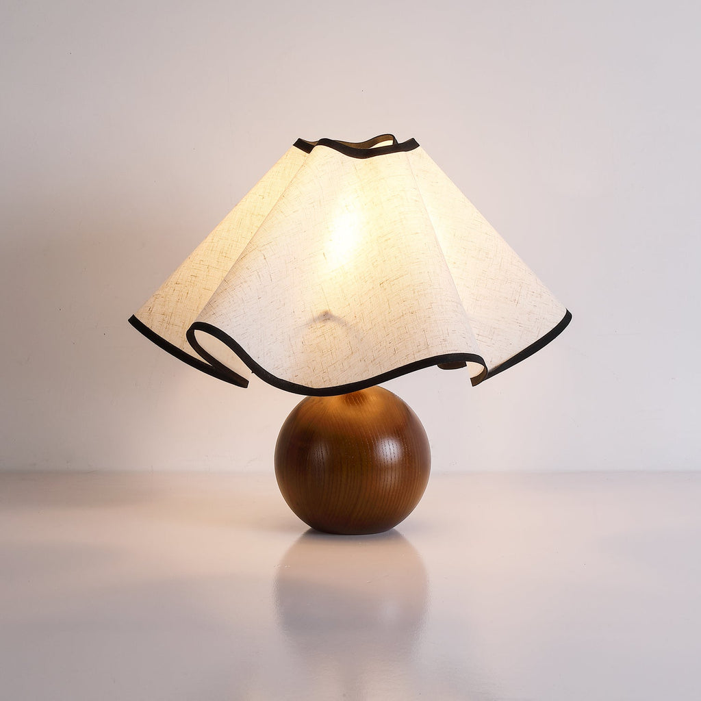 Wavecrest table lamp with wave-draped linen shade glowing softly on a side table
