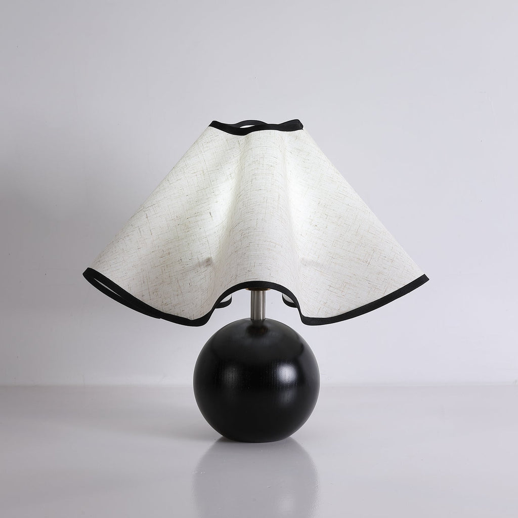 Wavecrest table lamp lit warmly on a wooden console