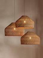 Three sizes of this Clérachic pendant hang together at staggered heights above a console table.