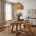 This Clérachic pendant hangs over a round table with wishbone chairs, a jug of dried pampas grass at its centre.