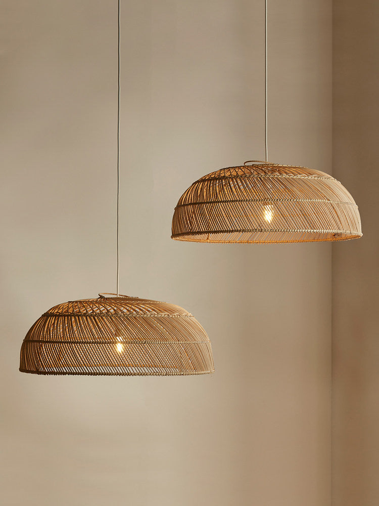 Two sizes of this Clérachic pendant hang at staggered heights against a plain wall.