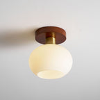 Tilted to show the open rim of its opal glass shade, this Clérachic ceiling light sits unlit.