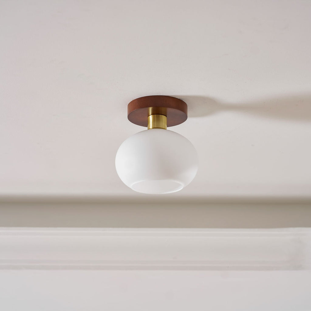 Angled close against a curved white crown moulding, this Clérachic ceiling light sits unlit.