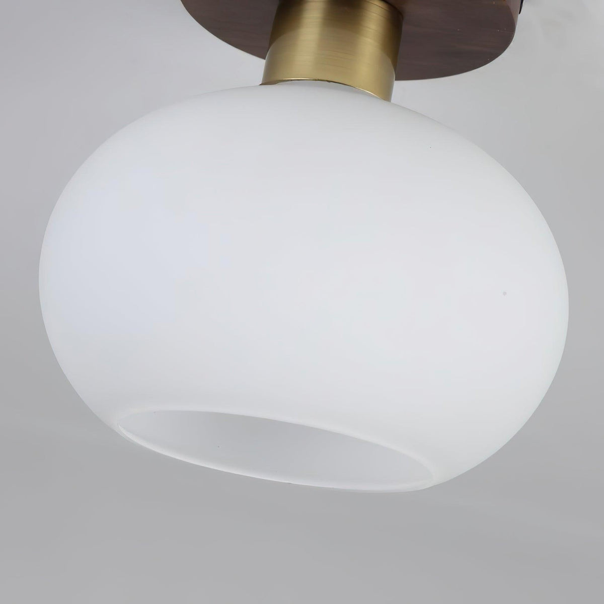 Close view of the opal glass shade on this Clérachic ceiling light, unlit against a grey backdrop.