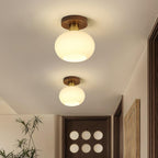Two of these Clérachic ceiling lights line a hallway ceiling above a dark panelled door with round cut-outs.