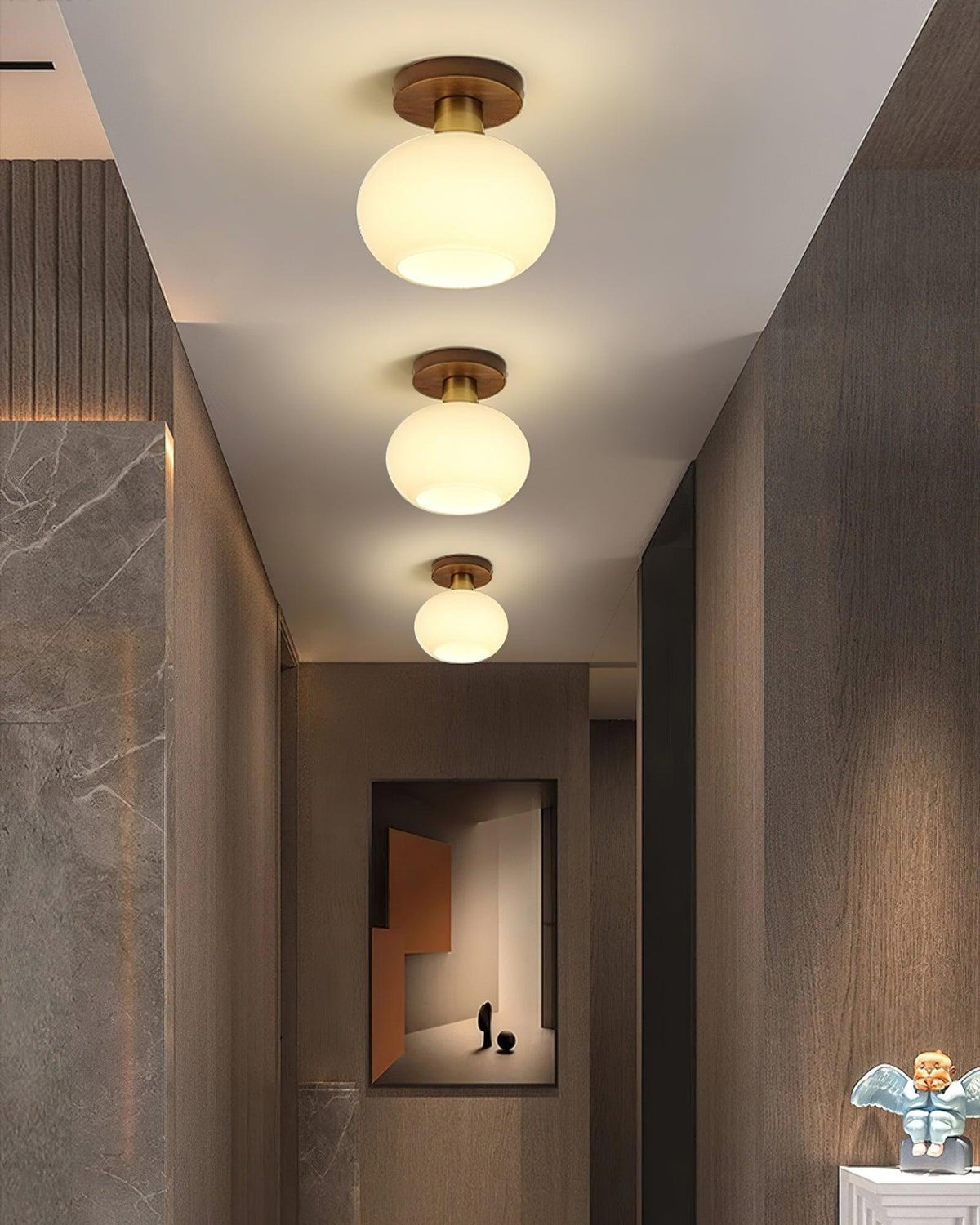 A round mirror and marbled wall sit beneath three of these Clérachic ceiling lights in a hallway.