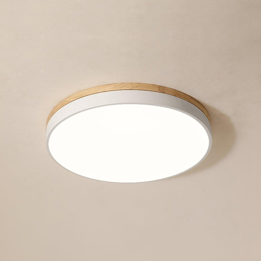 White ceiling light with warm wood rim in a bedroom