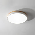 Round wooden ceiling light lit in a bright bedroom