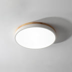 Round wooden ceiling light lit in a bright bedroom