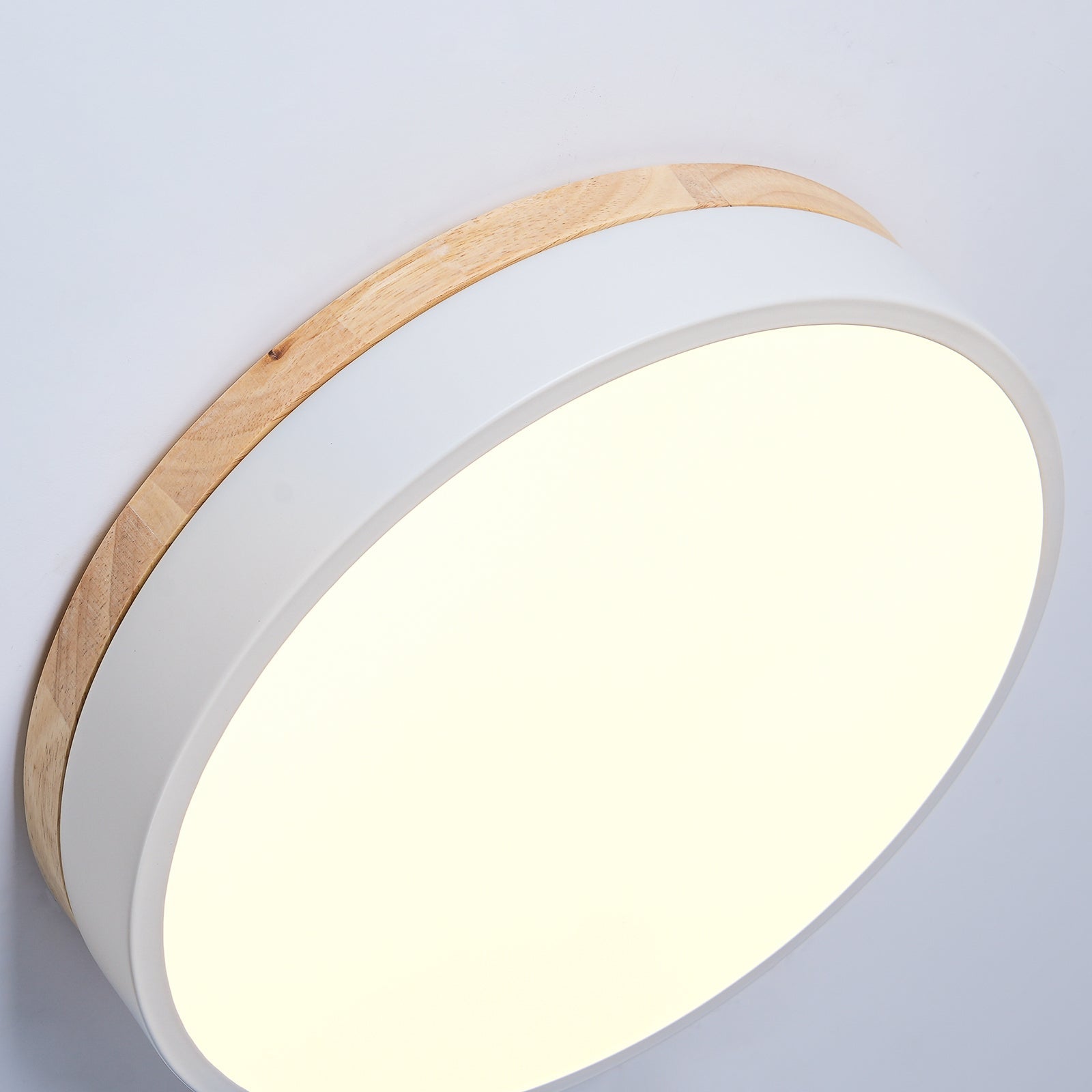 Wood and white ceiling light angled to show the rim
