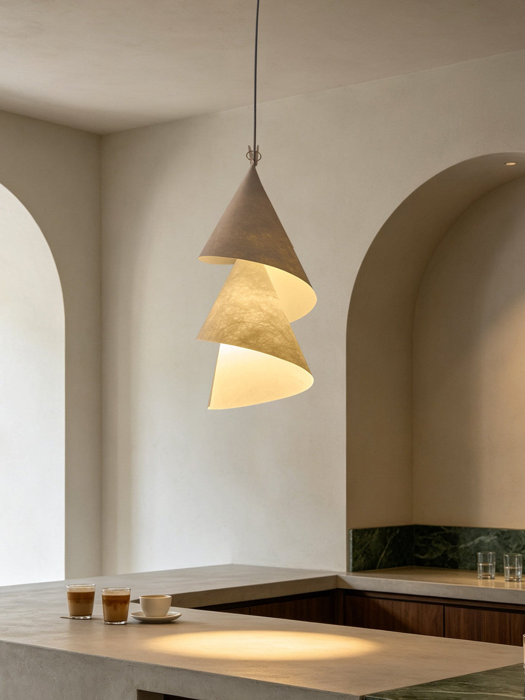 In an arched kitchen nook beside espresso cups, this Clérachic pendant shows grey and cream cones.