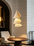 Beside an armchair and a round dark-wood table, this Clérachic pendant's cones spiral downward.