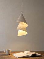 Above a small table set with a mug and an open notebook, this Clérachic pendant hangs alone.