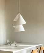 Above a white table set with wine glasses, this Clérachic pendant's cones spiral downward.