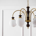 Walnut and gold chandelier centerpiece in a dining room