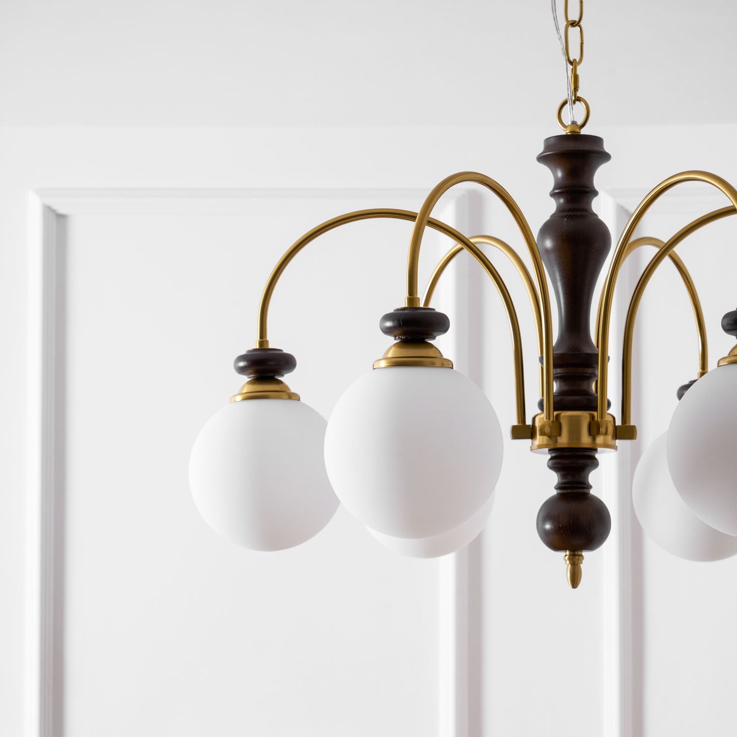 Walnut and gold chandelier centerpiece in a dining room