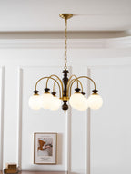 Walnut gold chandelier glowing above a styled table