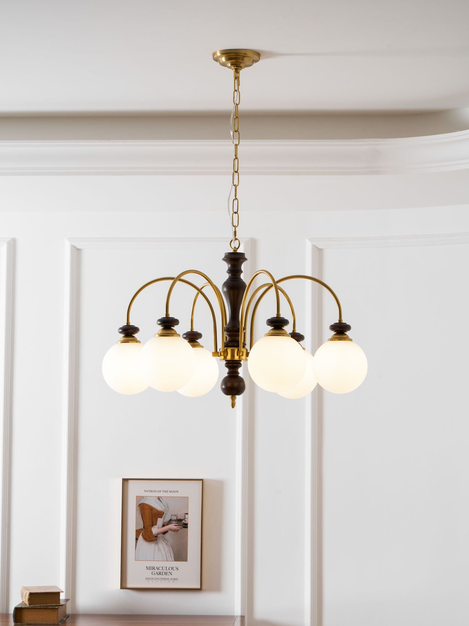 Walnut gold chandelier glowing above a styled table