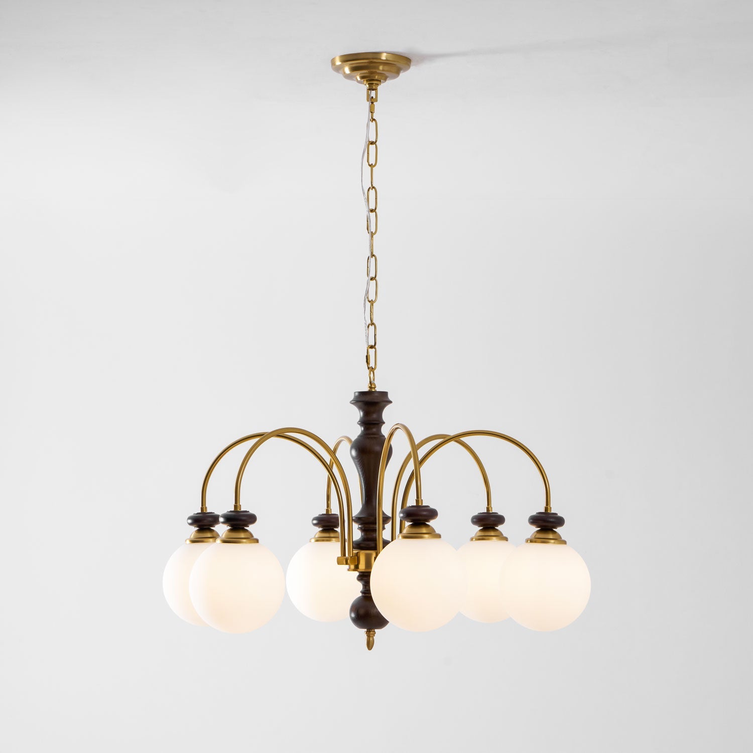 Walnut and gold chandelier full view glowing softly