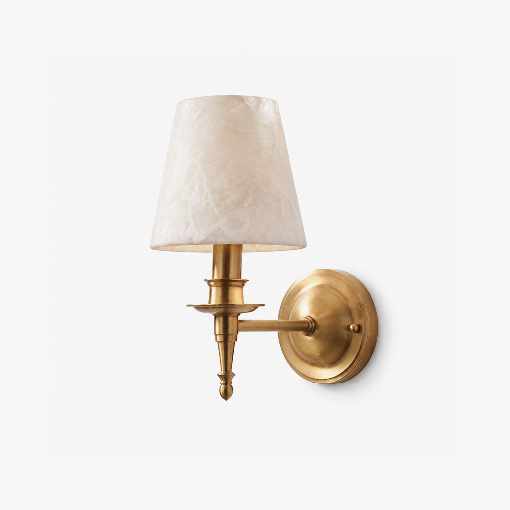 This brushed brass Clérachic wall sconce shows its scalloped drip pan and alabaster cone shade on a plain white background.