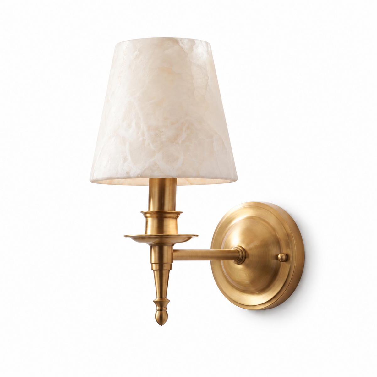 A brushed brass Clérachic wall sconce with a tapered alabaster cone shade on a turned candlestick column, lit against white.