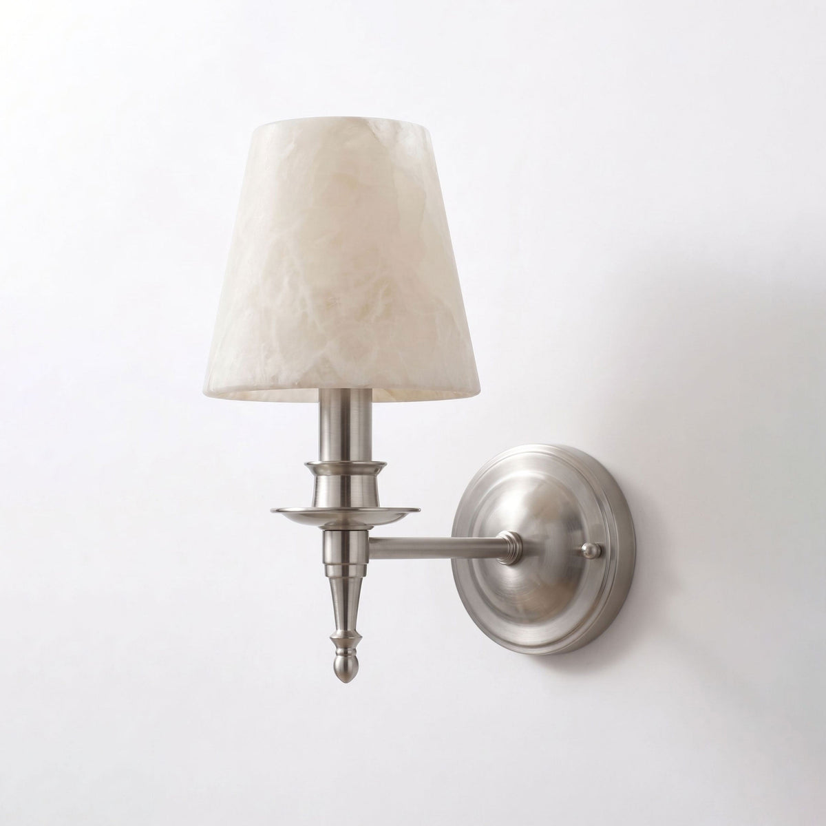 Unlit on a plain white background, this brushed nickel Clérachic wall sconce reveals its turned candlestick column.