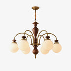 Walnut and gold chandelier shown against a pale wall